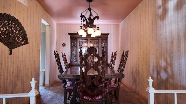 carpeted dining area with baseboards, a notable chandelier, and wallpapered walls