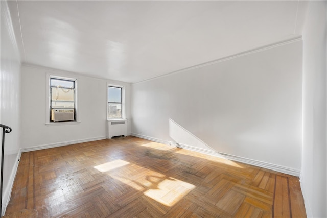 spare room featuring cooling unit, parquet flooring, ornamental molding, and radiator