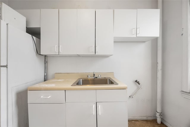 kitchen with white cabinets, white fridge, and sink