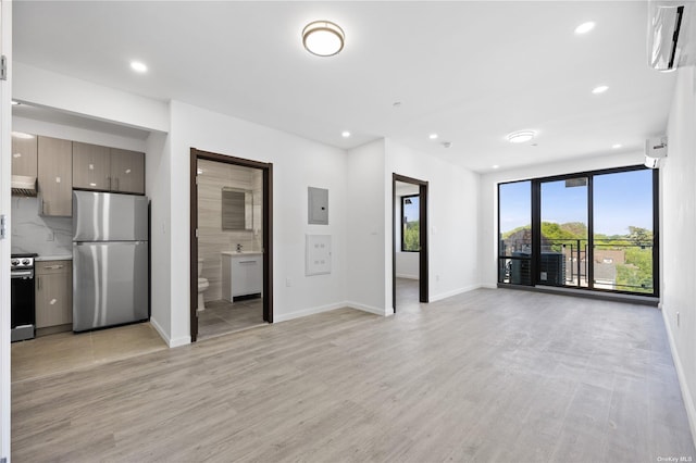 unfurnished living room featuring electric panel and light wood-type flooring