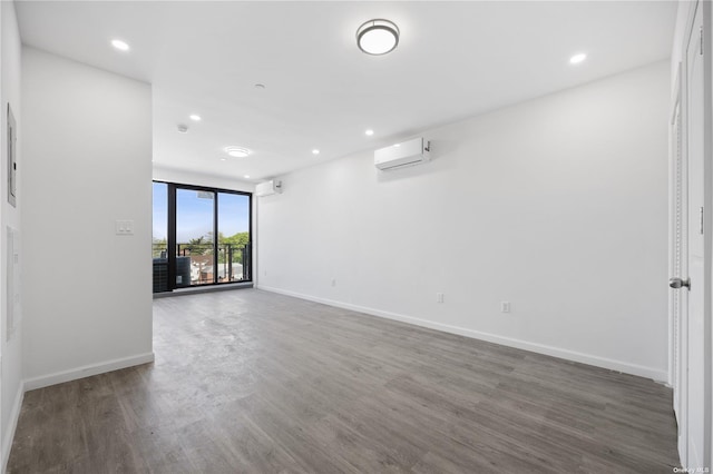 unfurnished room featuring an AC wall unit and dark wood-type flooring