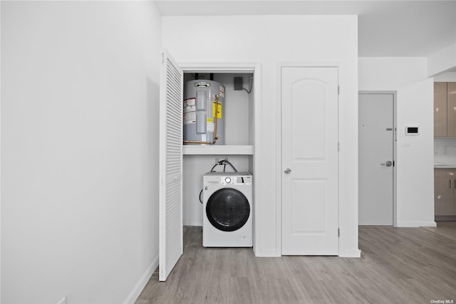 laundry area featuring washer / dryer, electric water heater, and light wood-type flooring