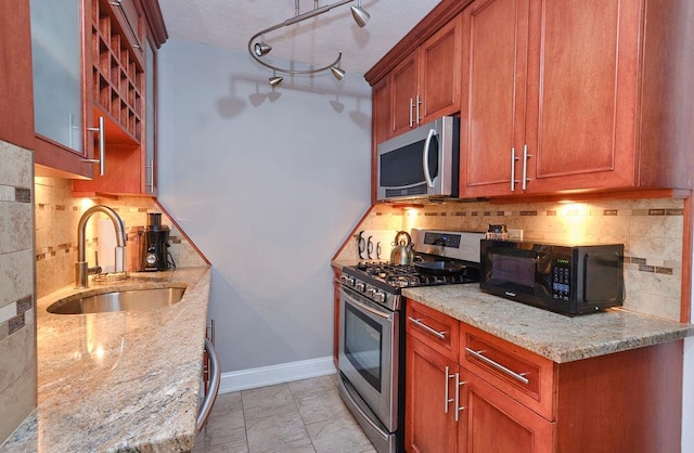 kitchen featuring sink, decorative backsplash, light stone countertops, light tile patterned flooring, and stainless steel appliances