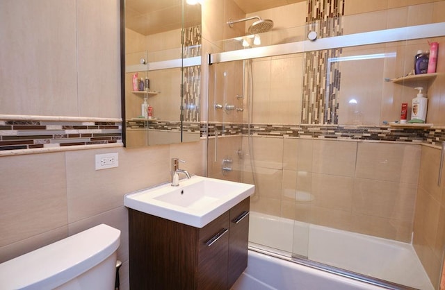 full bathroom with shower / bath combination with glass door, vanity, and toilet