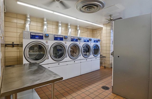 laundry room with washer and dryer, ceiling fan, and dark tile patterned floors