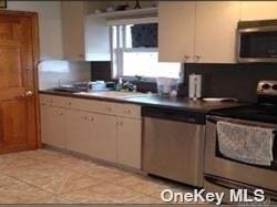 kitchen featuring white cabinets, light tile patterned floors, and stainless steel appliances