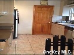 kitchen with sink, refrigerator, and light tile patterned flooring