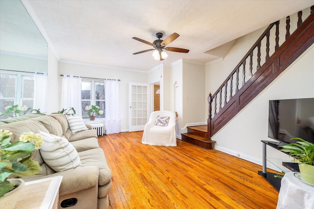 living room with ceiling fan, radiator heating unit, crown molding, and hardwood / wood-style flooring