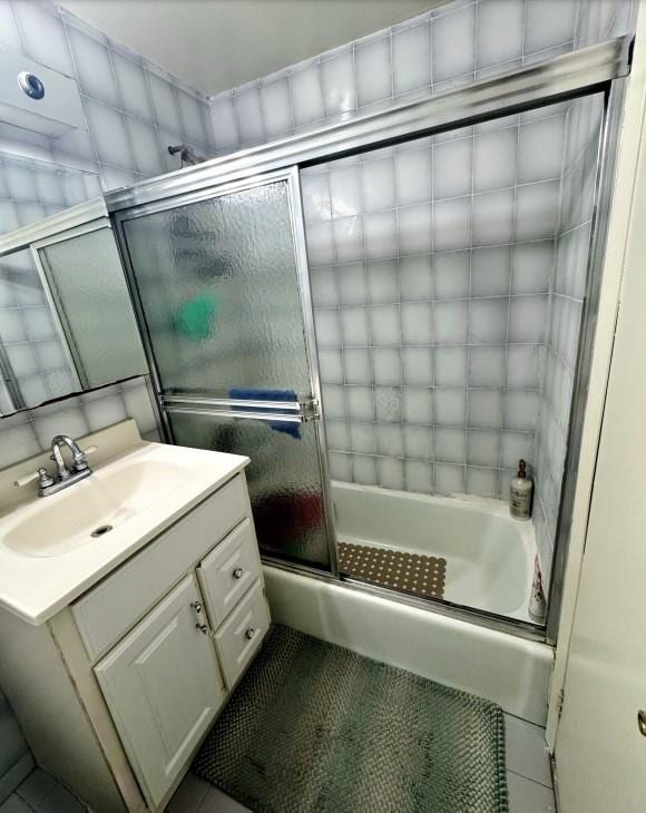 bathroom featuring combined bath / shower with glass door, vanity, and tile patterned floors