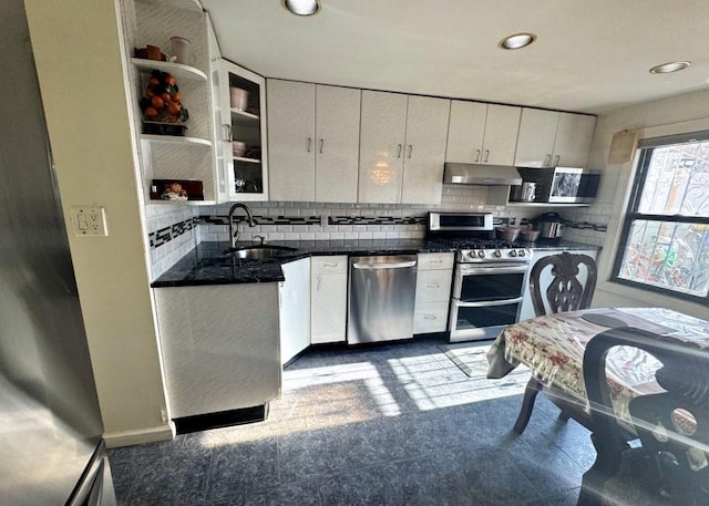 kitchen with white cabinets, appliances with stainless steel finishes, backsplash, and sink