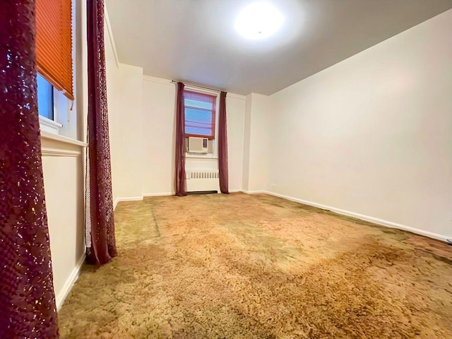 unfurnished room featuring cooling unit, radiator, and carpet floors