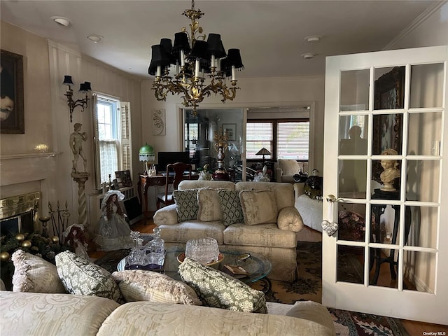 living room featuring a tiled fireplace, a wealth of natural light, a chandelier, and wood-type flooring