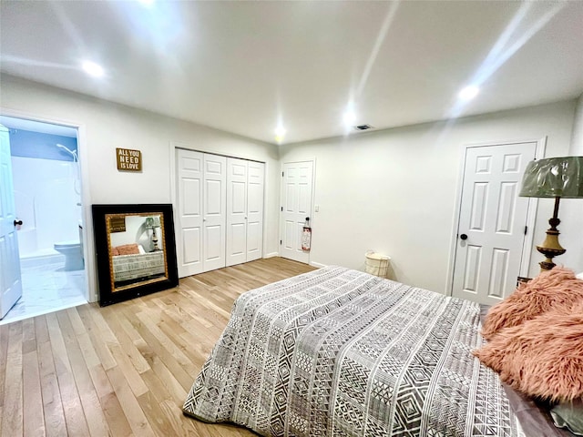 bedroom with connected bathroom and light hardwood / wood-style flooring