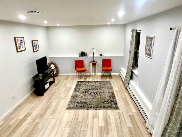 living area featuring a baseboard radiator and light wood-type flooring