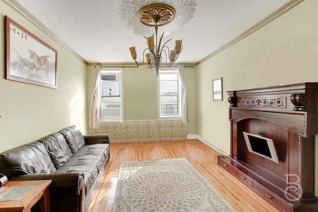 living room with light wood-type flooring, ornamental molding, and a notable chandelier