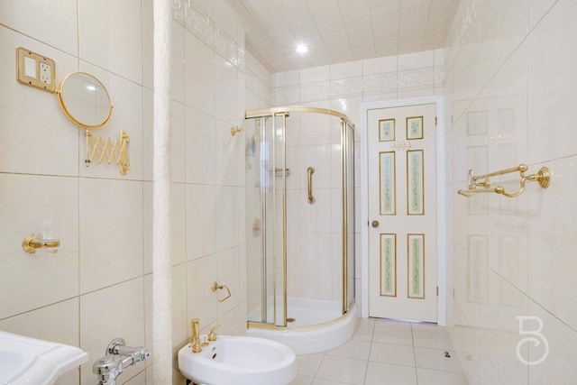 bathroom with tile patterned flooring, a bidet, a shower with door, and tile walls