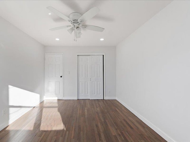 unfurnished bedroom with ceiling fan, dark hardwood / wood-style flooring, and a closet