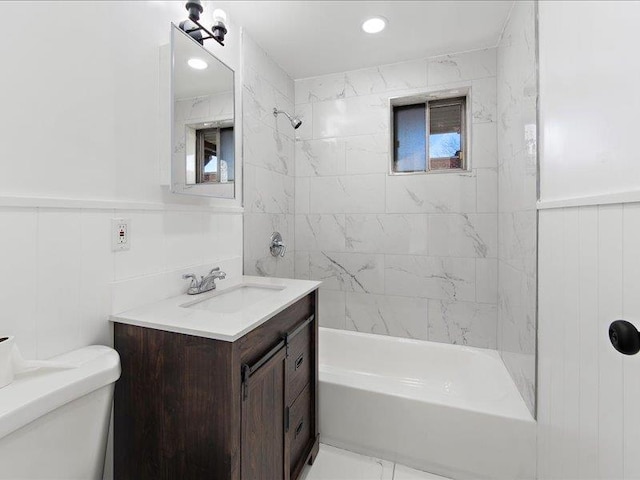 full bathroom featuring tiled shower / bath combo, toilet, and vanity