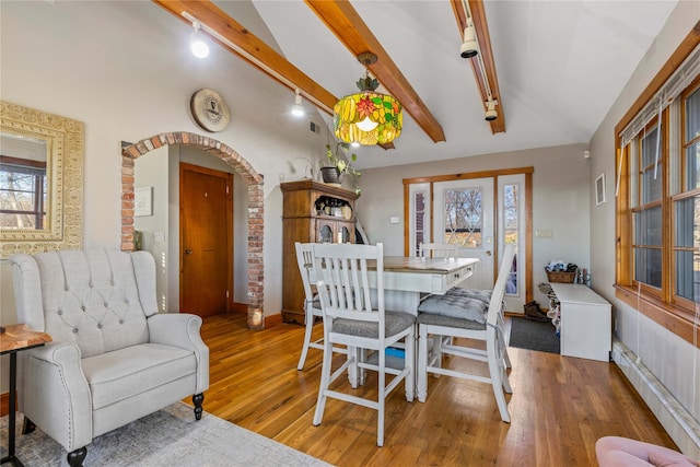 dining room featuring hardwood / wood-style flooring and lofted ceiling with beams