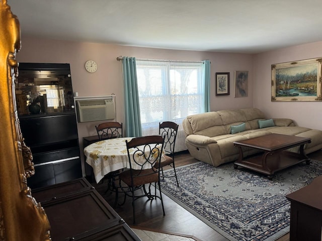 living room with a wall mounted air conditioner and hardwood / wood-style flooring