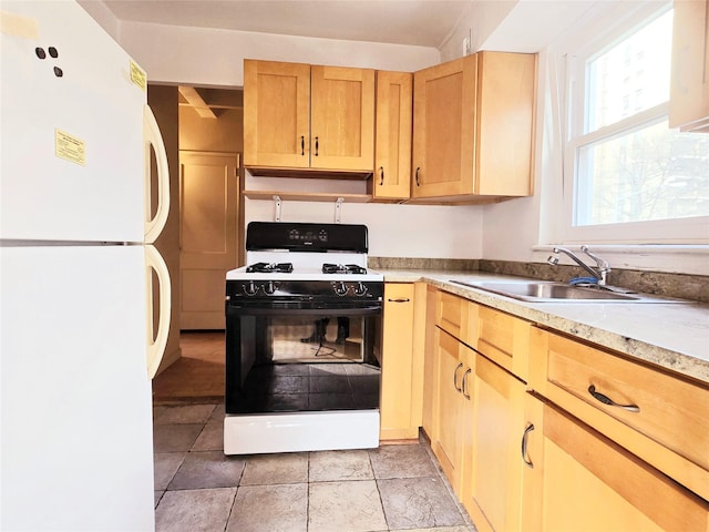 kitchen featuring white appliances, sink, and light brown cabinetry