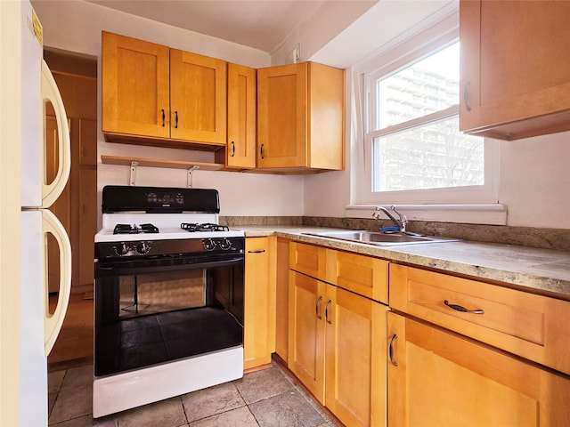 kitchen featuring white appliances, sink, and light tile patterned floors