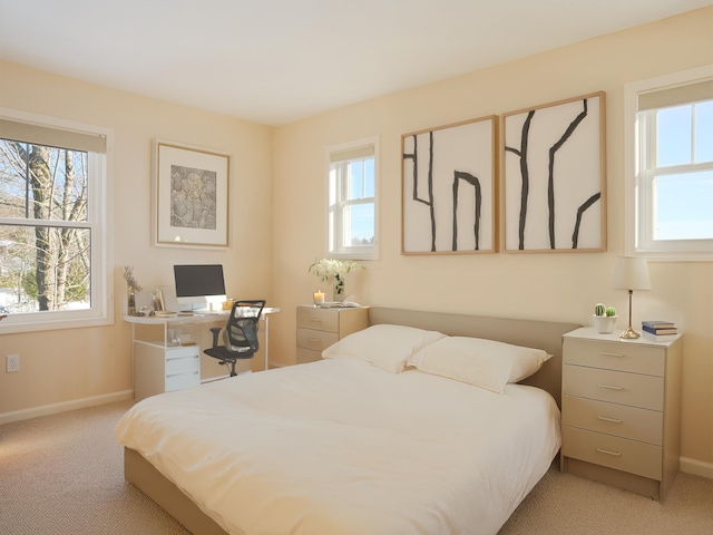 bedroom with multiple windows, baseboards, and light colored carpet