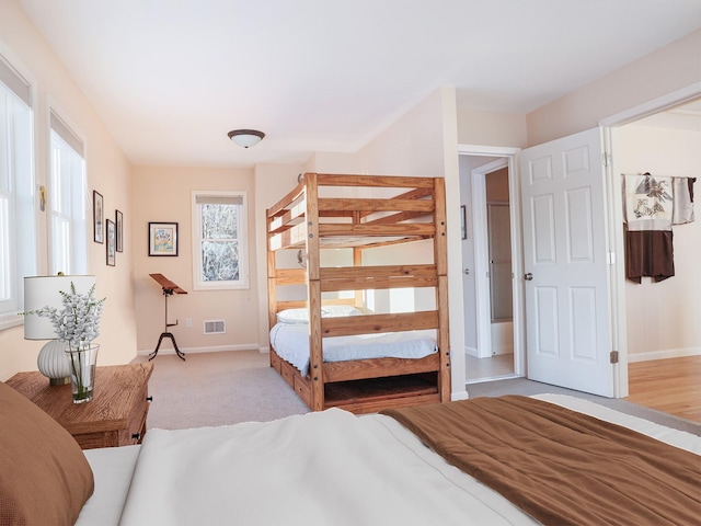 bedroom featuring light colored carpet, visible vents, and baseboards