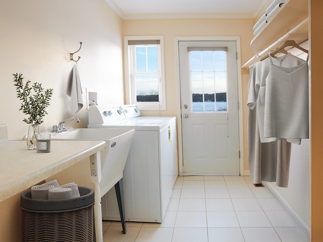 clothes washing area with ornamental molding, laundry area, independent washer and dryer, and light tile patterned floors