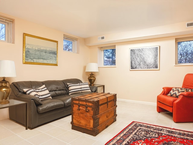 living room with baseboards, light tile patterned floors, visible vents, and a healthy amount of sunlight