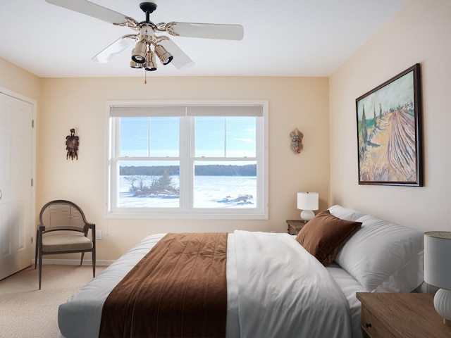 bedroom with a ceiling fan, light carpet, and baseboards