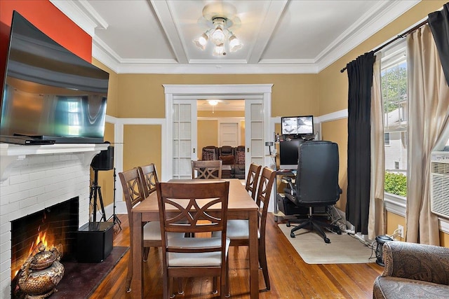 dining space featuring a fireplace, hardwood / wood-style flooring, a wealth of natural light, and coffered ceiling