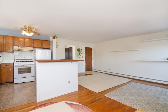 kitchen featuring tasteful backsplash, light wood-type flooring, baseboard heating, ceiling fan, and white appliances