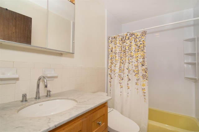 full bathroom featuring vanity, tile walls, shower / bath combo with shower curtain, and toilet