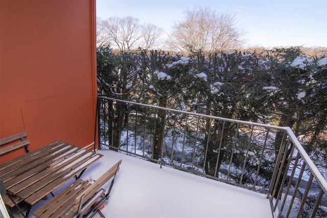 view of snow covered back of property