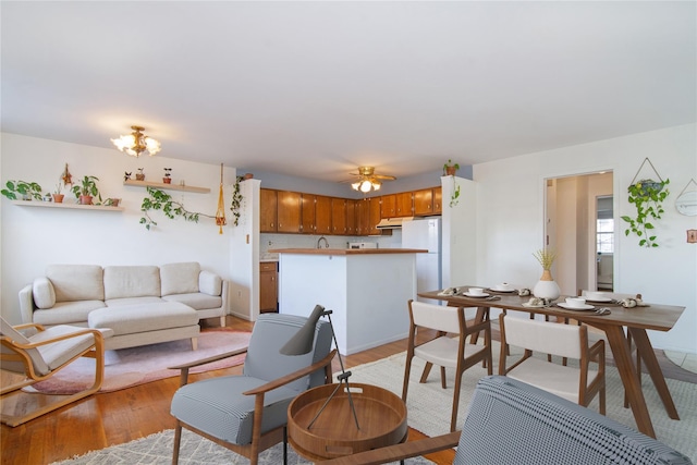 living room with ceiling fan and light hardwood / wood-style flooring