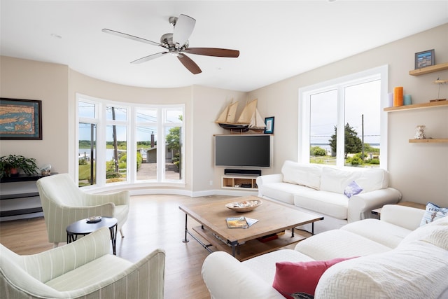 living room with light hardwood / wood-style floors and ceiling fan