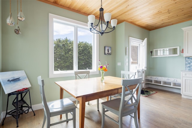 dining room featuring a chandelier, ornamental molding, light wood-type flooring, and wooden ceiling