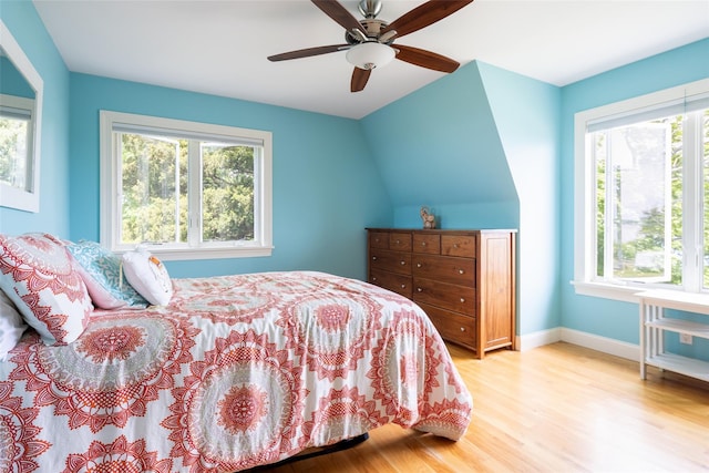 bedroom with vaulted ceiling, light hardwood / wood-style flooring, and ceiling fan