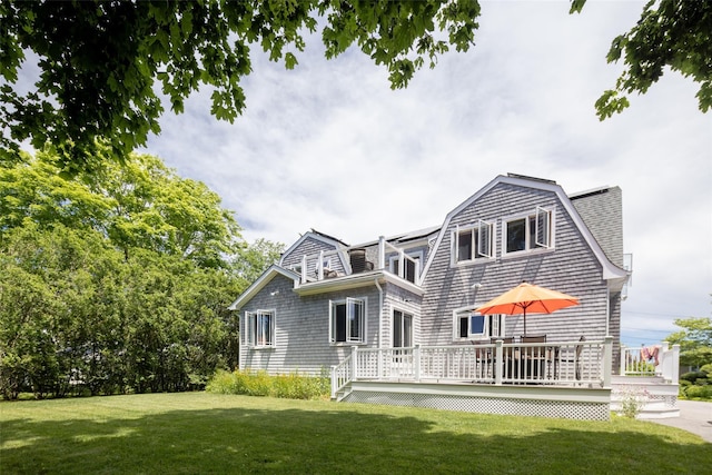 rear view of property featuring a lawn and a deck