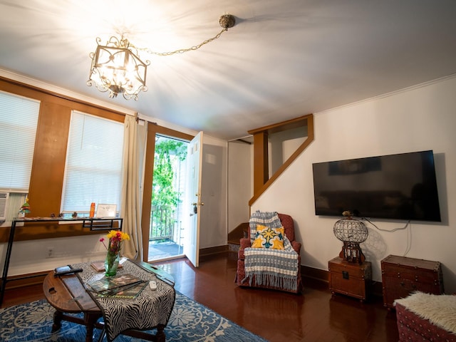 living room featuring ornamental molding, dark wood-type flooring, and a notable chandelier