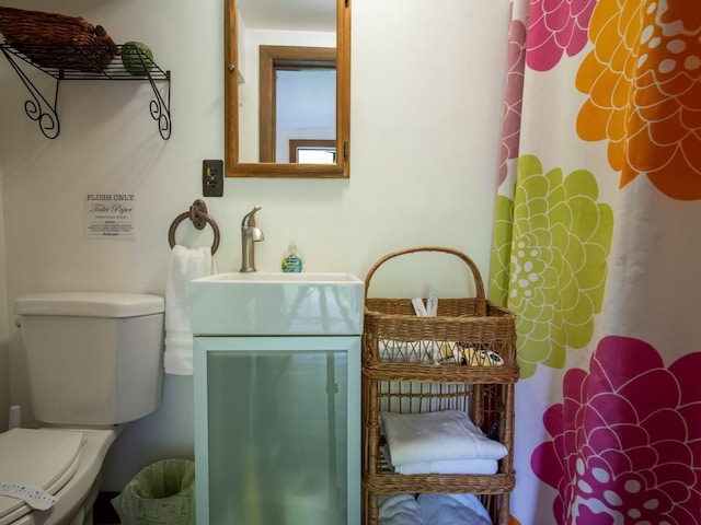 bathroom with a shower with curtain, sink, and toilet