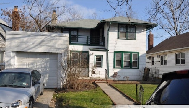 view of front of property featuring a balcony, a front lawn, and a garage