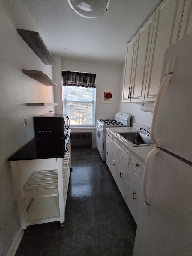 kitchen featuring white cabinets, radiator heating unit, white appliances, and sink