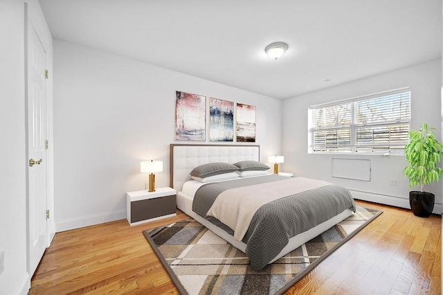 bedroom with a baseboard heating unit and hardwood / wood-style flooring