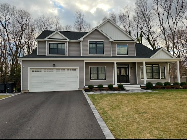 view of front of home with a front lawn, a porch, and a garage