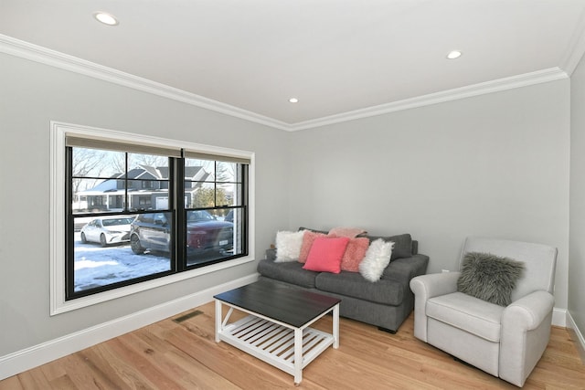 living room featuring crown molding and light hardwood / wood-style flooring