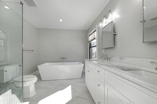 bathroom featuring a tub to relax in, toilet, and vanity