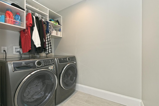 clothes washing area with separate washer and dryer