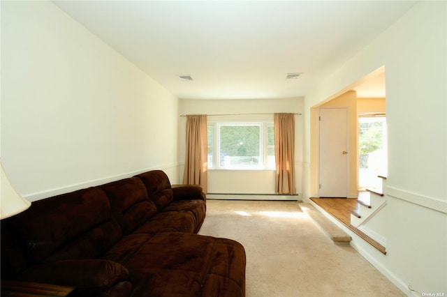 living room featuring light colored carpet and a baseboard heating unit